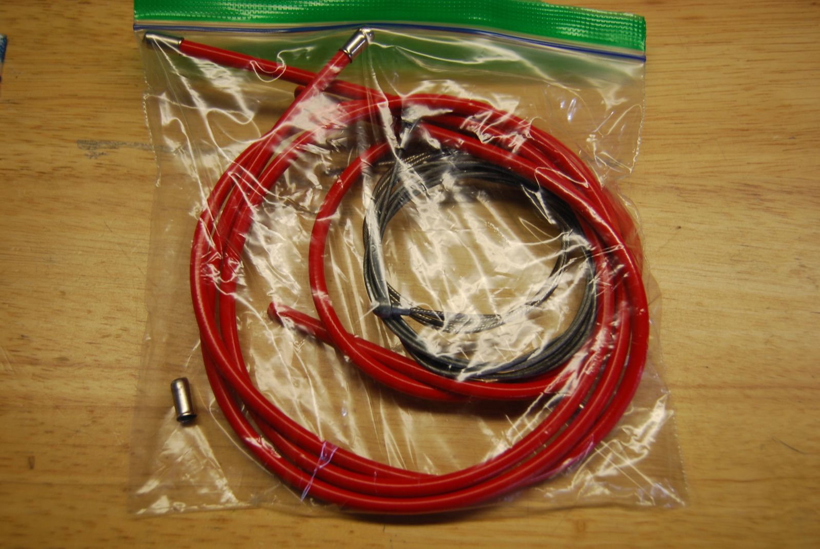 Red road bike brake cable and housing.