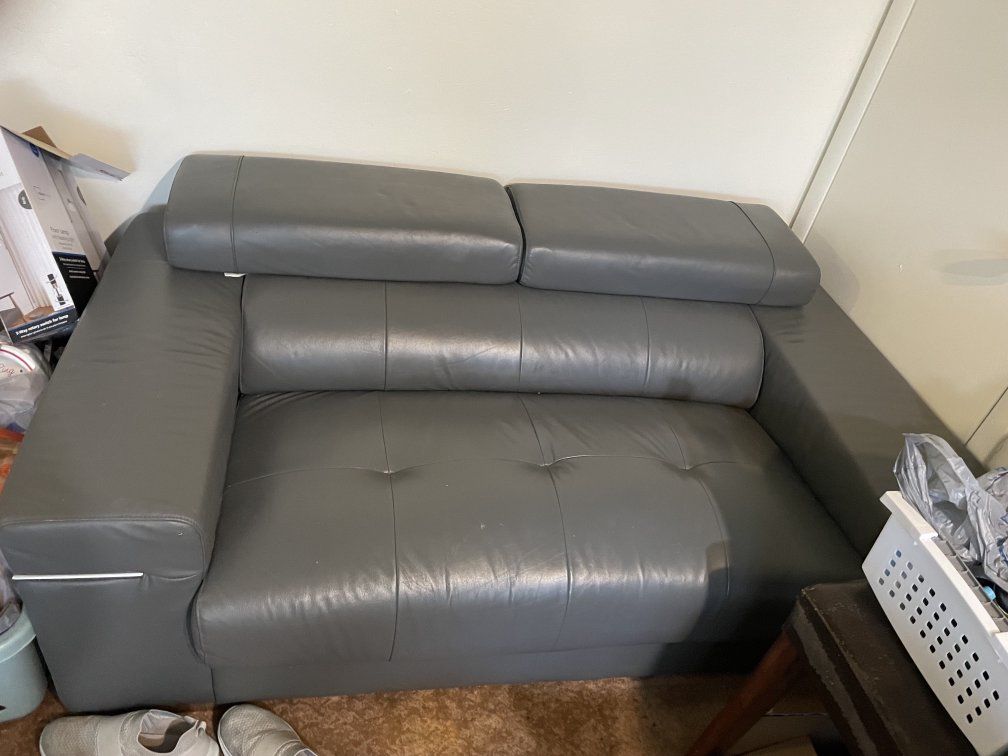 Used Grey Leather Loveseat Sofa and two tvs- Good Condition