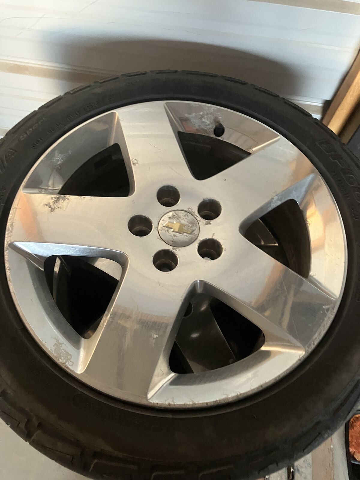 Chevy rims with tires and lug nuts. 215/50R17