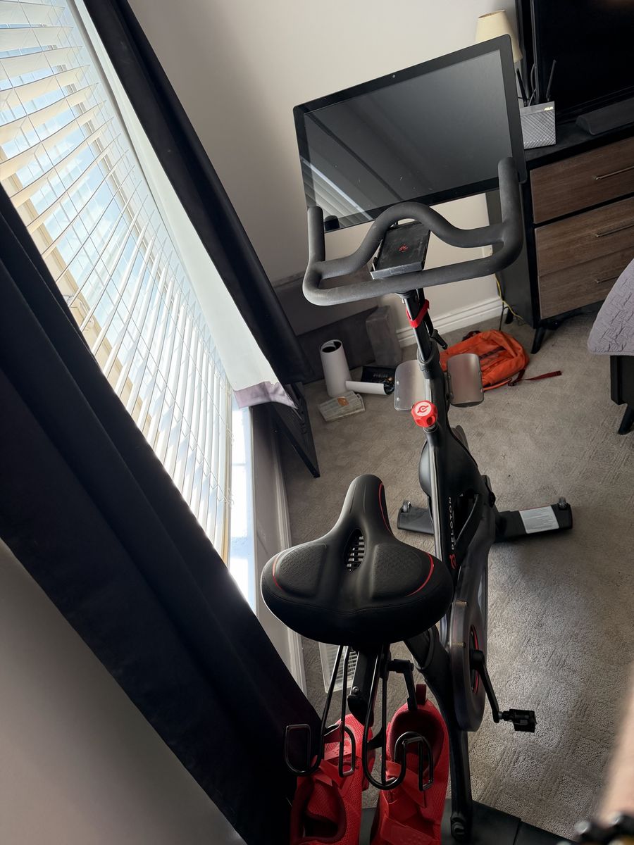 Peloton Indoor Exercise Bike with Upgraded Seat, Mat, and Phone Tray