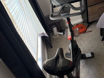 Peloton Indoor Exercise Bike with Upgraded Seat, Mat, and Phone Tray
