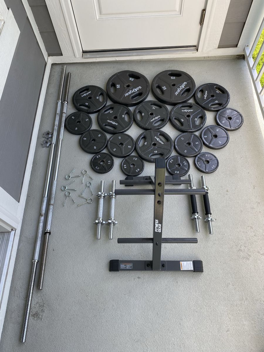 1 inch weight plates with bars, dumbbell handles, and storage rack
