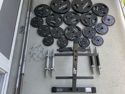 1 inch weight plates with bars, dumbbell handles, and storage rack