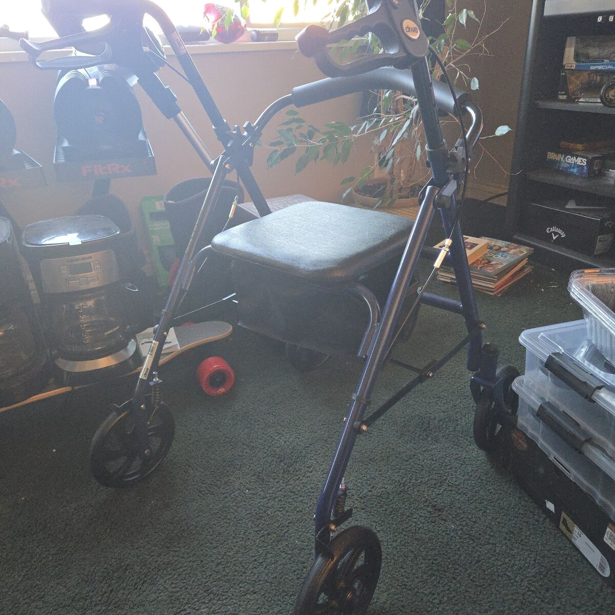 Folding walker with storage bin and brakes