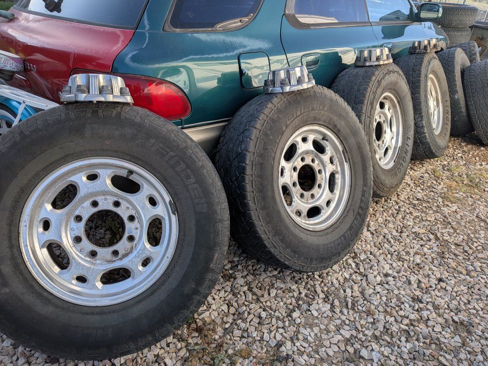 Chevy 8x6.5 16 wheels and tires with center caps.
