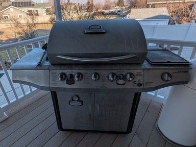 Smoke n' Grill Professional 5 Burner Gas Grill with Smoker and Propane Tank with a cover.