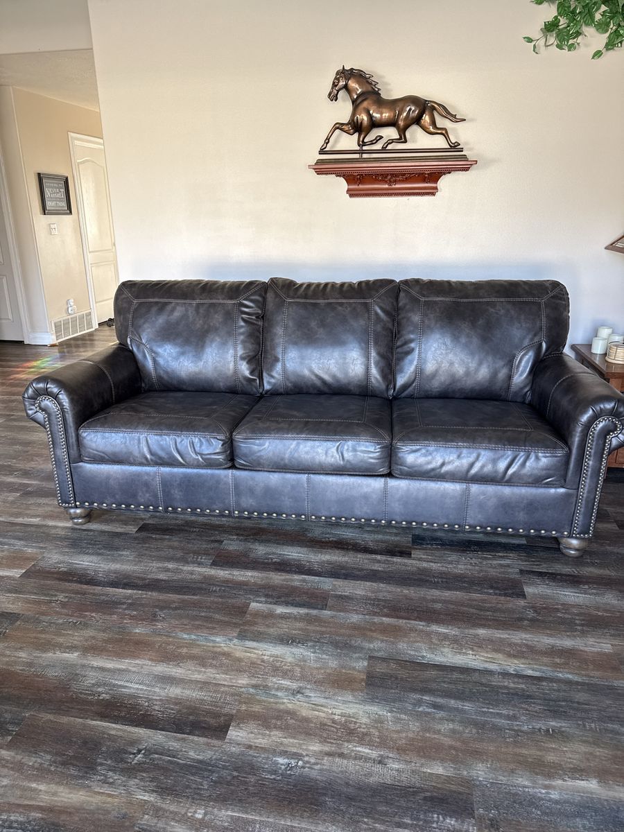 Dark Brown  distressed leather looking Vinyl Sofa with Nailhead Trim and Rolled Arms by Ashley furniture 