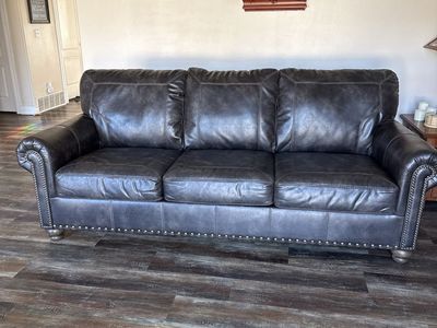 Dark Brown distressed leather looking Vinyl Sofa with Nailhead Trim and Rolled Arms by Ashley furniture