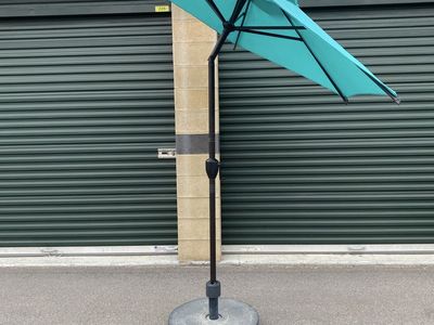 Teal patio umbrella with weighted stand.