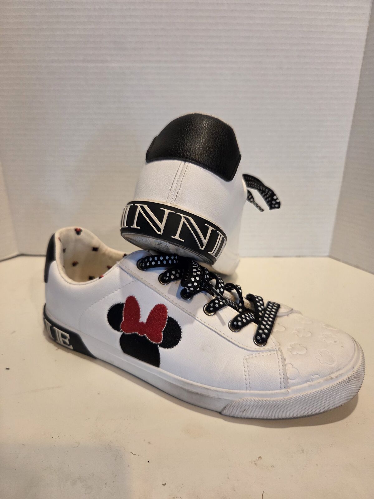 pair of Ground Up Disney Minnie Mouse Women's Low-top Court Sneakers in white faux leather. Size 10