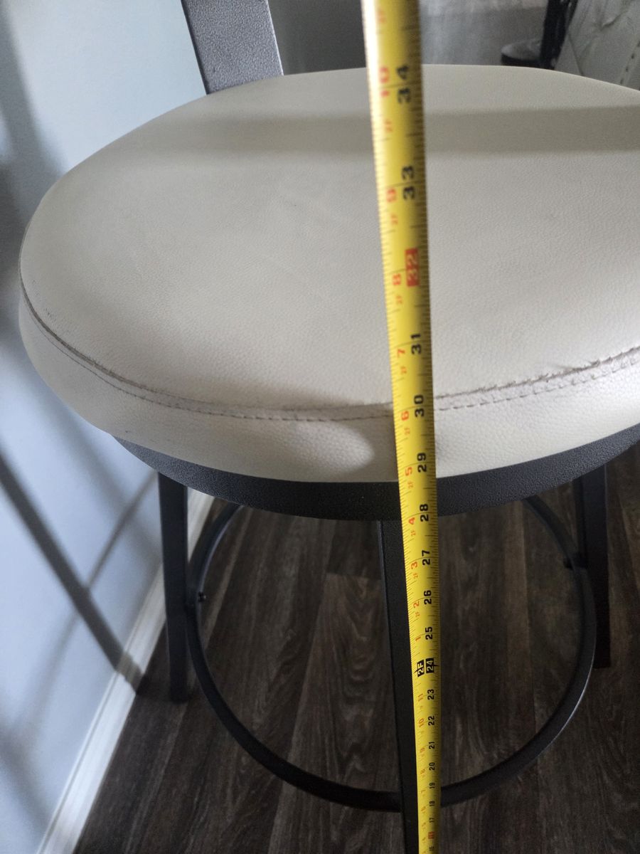 Modern swivel bar stool has white faux leather seat and backrest.