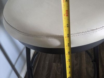 Modern swivel bar stool has white faux leather seat and backrest.