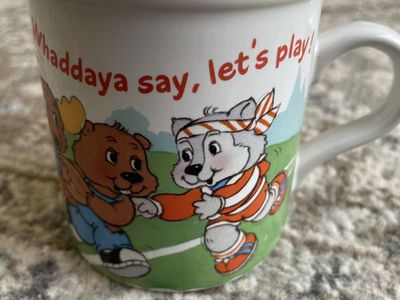 This vintage stoneware coffee mug features characters from The Get Along Gang and was produced by American Greetings in 1985