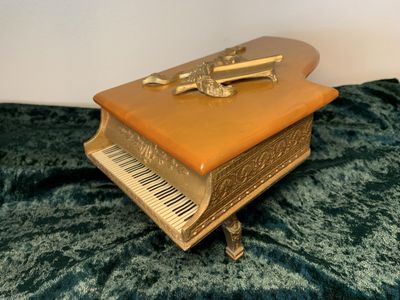 Vintage collectible: Thorens of Switzerland cast metal piano with butterscotch Bakelite top and working music box