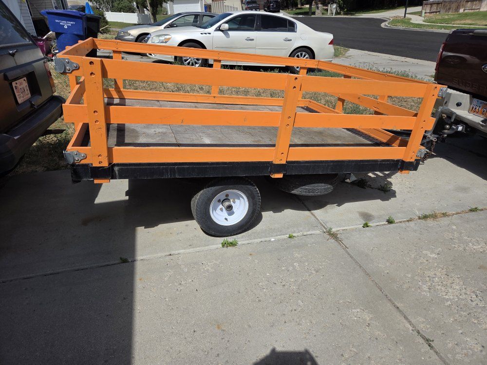 Utility Trailer - Small Orange/Black Open-Top, Single Axle.
