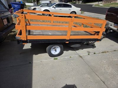 Utility Trailer - Small Orange/Black Open-Top, Single Axle.