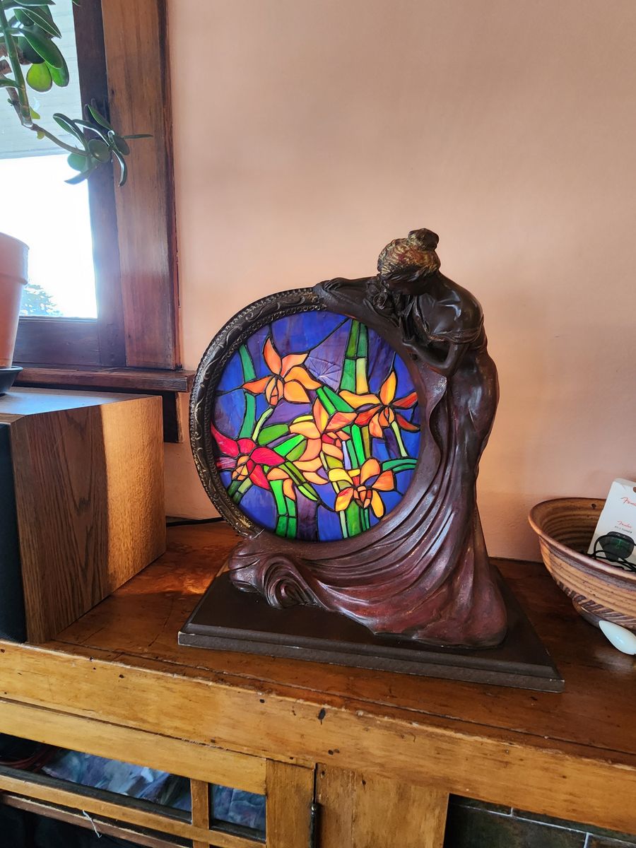 Interesting faux antique stained glass lamp with beautiful ceramic lady holding the frame.