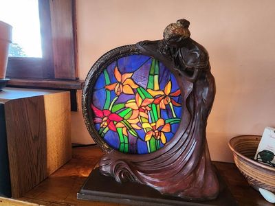 Interesting faux antique stained glass lamp with beautiful ceramic lady holding the frame.
