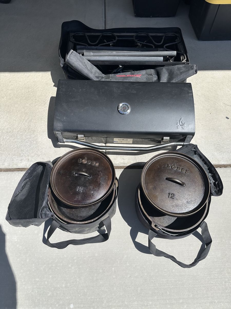Camp Chef Explorer 2-Burner Stove, Deluxe BBQ grill box, and 2 Lodge 12" Dutch Ovens with cases.