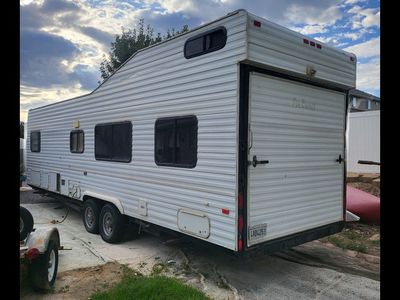 Used Travel Trailer RV Interior with Kitchenette, Bathroom, and Sleeping Area